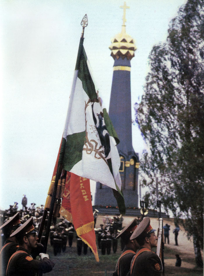 Перед главным монументом Бородинского поля торжественно проносят овеянные славой боевые знамена русских полков 1812 года и советских частей, защищавших эти рубежи осенью 1941-го